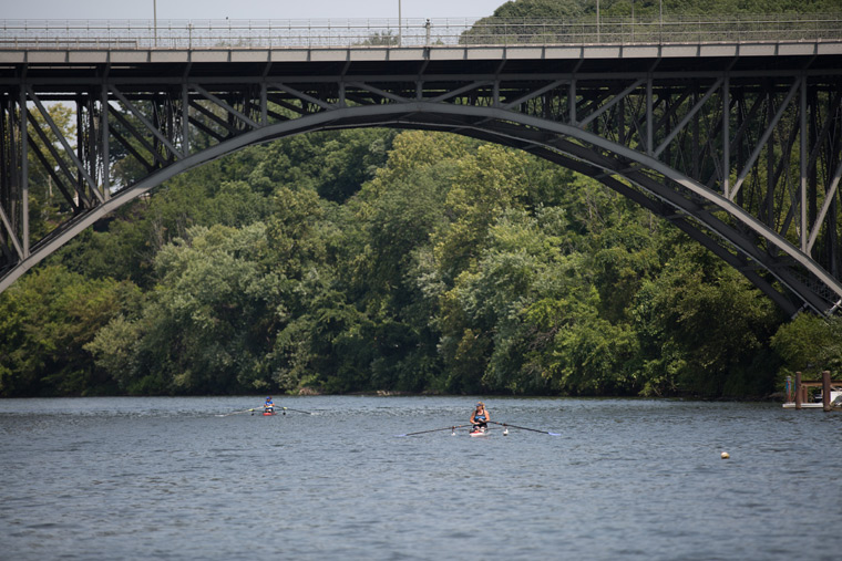 a rower going under a bridge on the river